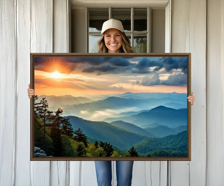 The wall art, titled Sunrise Over Mountain Range, is a canvas print that beautifully depicts layers of hills, scattered trees, and a partly cloudy sky.