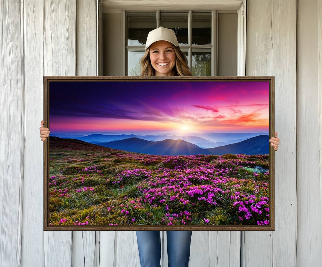 A 3-panel landscape photography canvas of a sunset over mountain meadows with purple wildflowers decorates the wall.