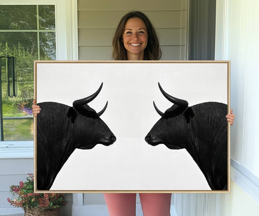 A framed canvas print featuring two black bull silhouettes, perfect for modern rustic decor.