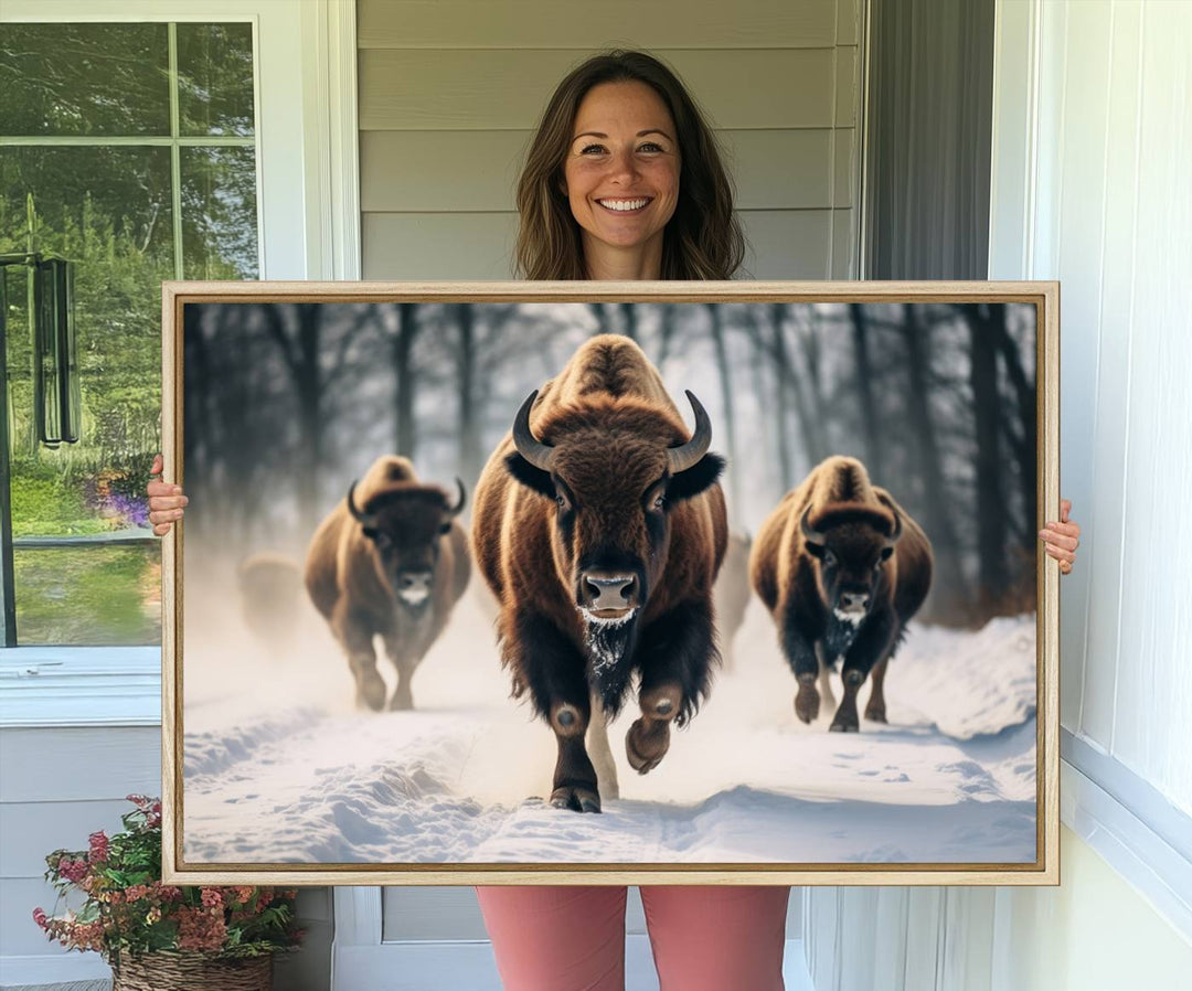 Wall art titled Cow Bighorn shows three bison running through snow in a forest.