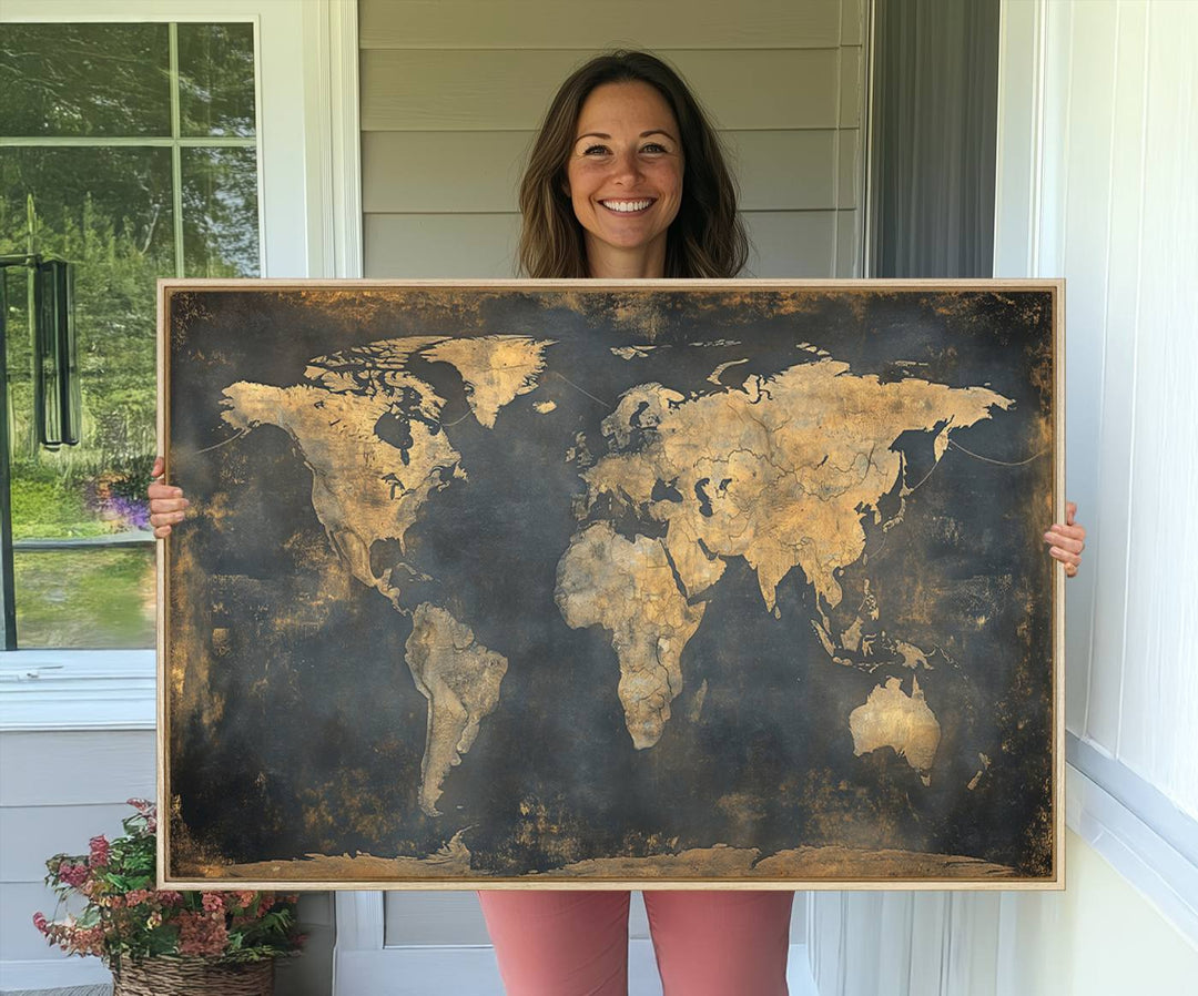 The Grunge World Map Canvas Wall Art features golden tones and is displayed against a white-paneled wall.