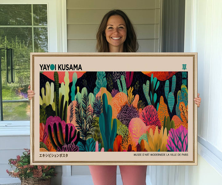 The vibrant canvas print of wall art features abstract plants, with the elegant text "Yayoi Kusama Wall Art Canvas Print" displayed on the colorful frame.