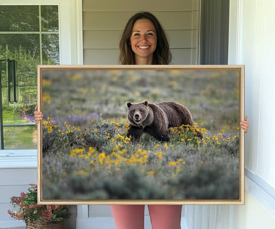 The "Grizzly 399 in Wild Flowers Wall Art Canvas Print" features a grizzly bear strolling through a field of yellow and purple flowers, beautifully showcased as a triptych. This handcrafted piece, proudly made in the USA, adds charm and sophistication to your space.