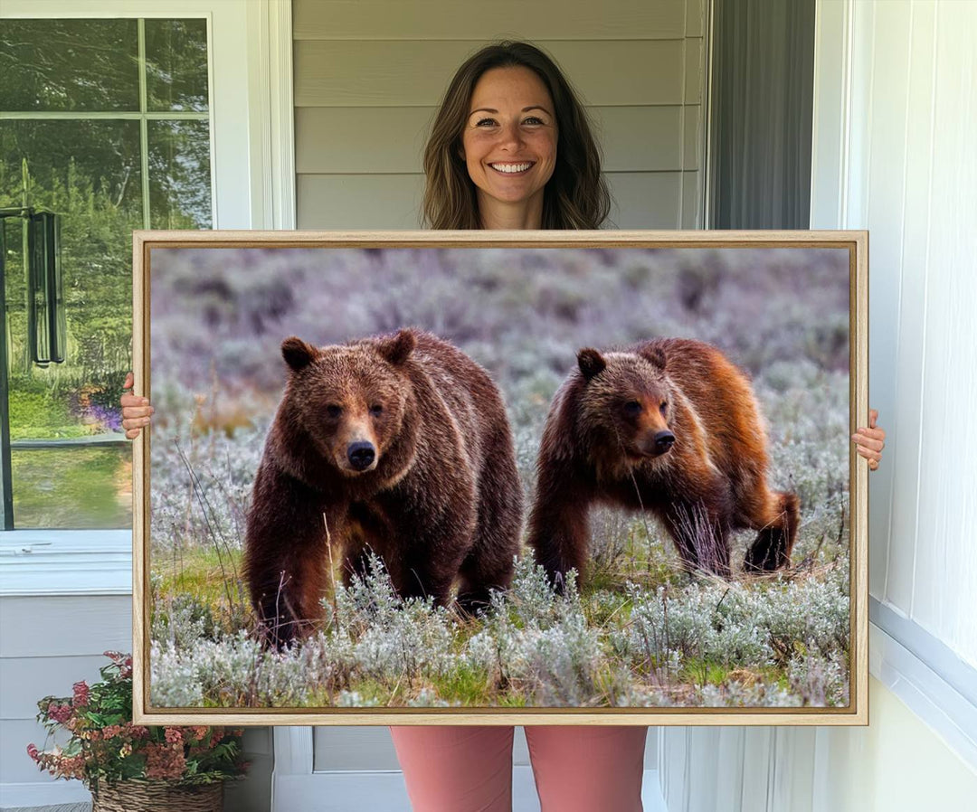 The "Queen of the Tetons" is a stunning canvas art print featuring Grizzly 399 and two bears strolling through a grassy field. Its gallery-quality finish beautifully captures the essence of nature, making it perfect for rustic home decor.