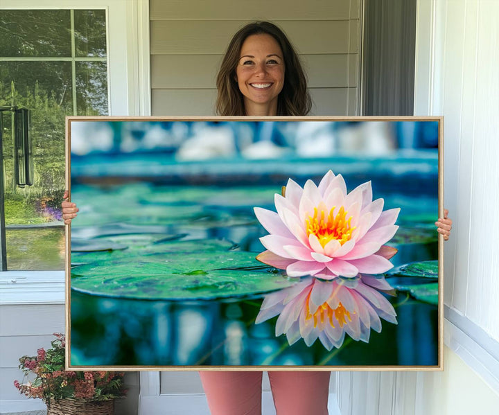 The Lotus Flower Canvas Print showcases a pink water lily with a yellow center gracefully floating on a calm pond.