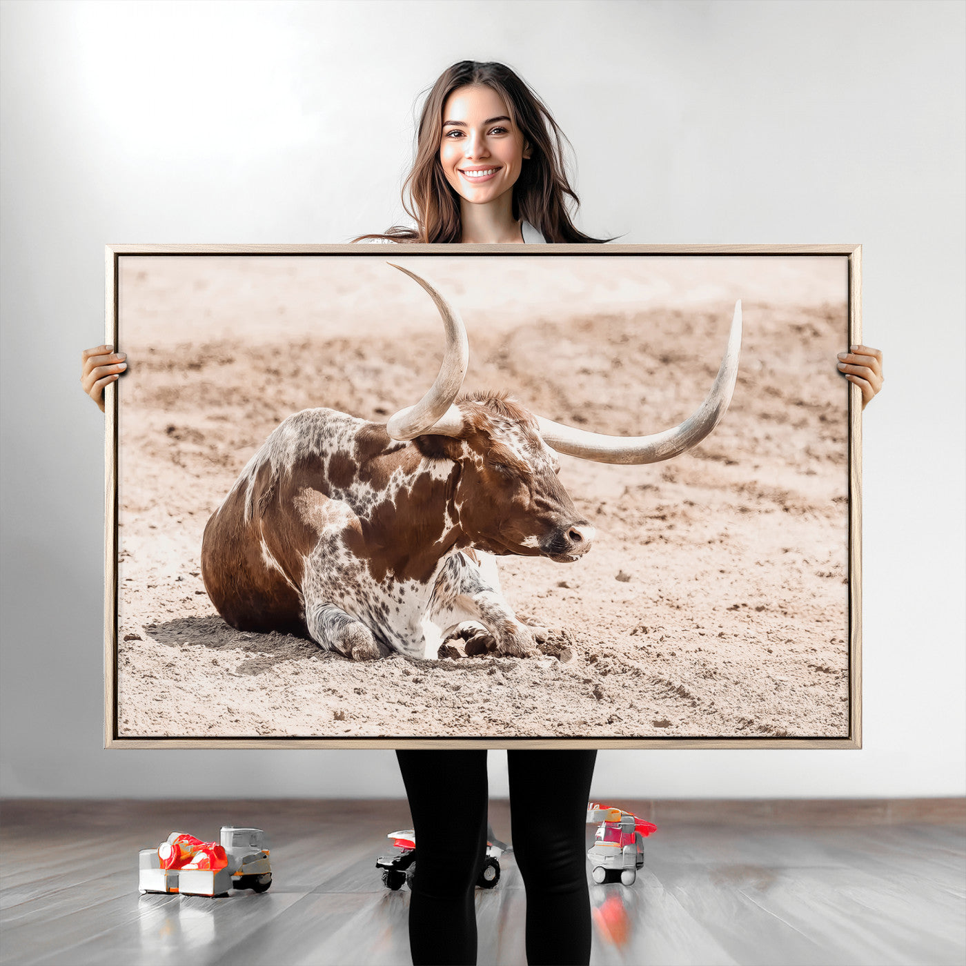 Texas Longhorn bull resting on dusty ground with warm tones, ideal for rustic western or farmhouse-themed wall decor.