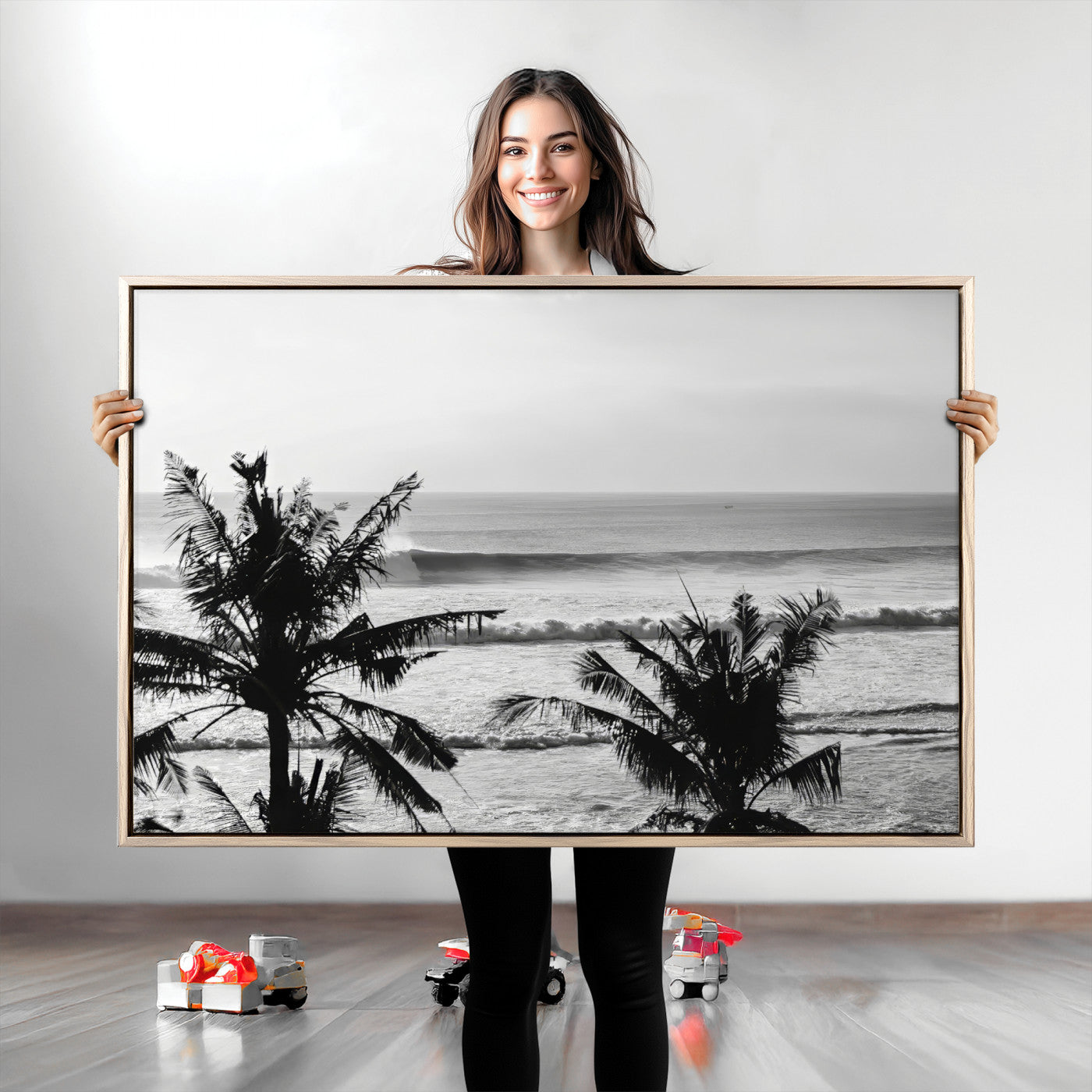 Black and white view of ocean waves crashing on a tropical coastline, framed by silhouetted palm trees under a vast, open sky.
