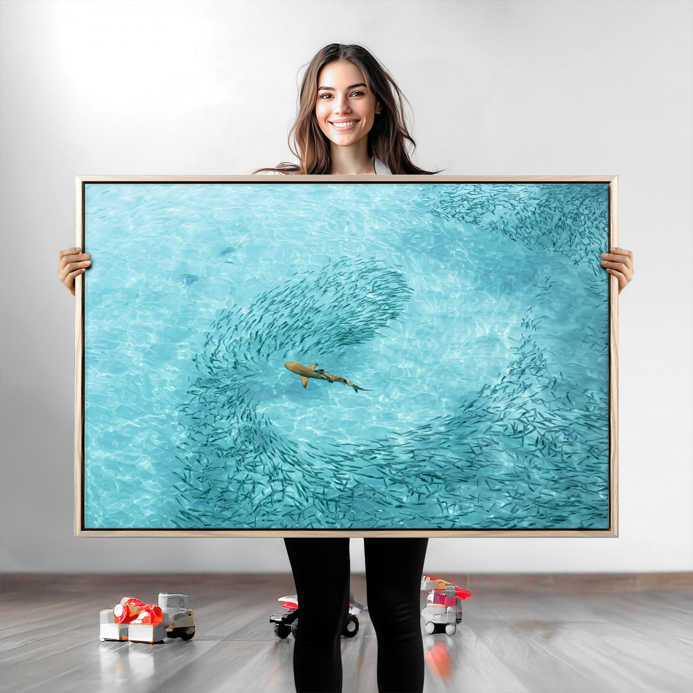 Aerial view of a shark swimming through a swirl of fish in clear turquoise waters, perfect for calm coastal or beach house decor.