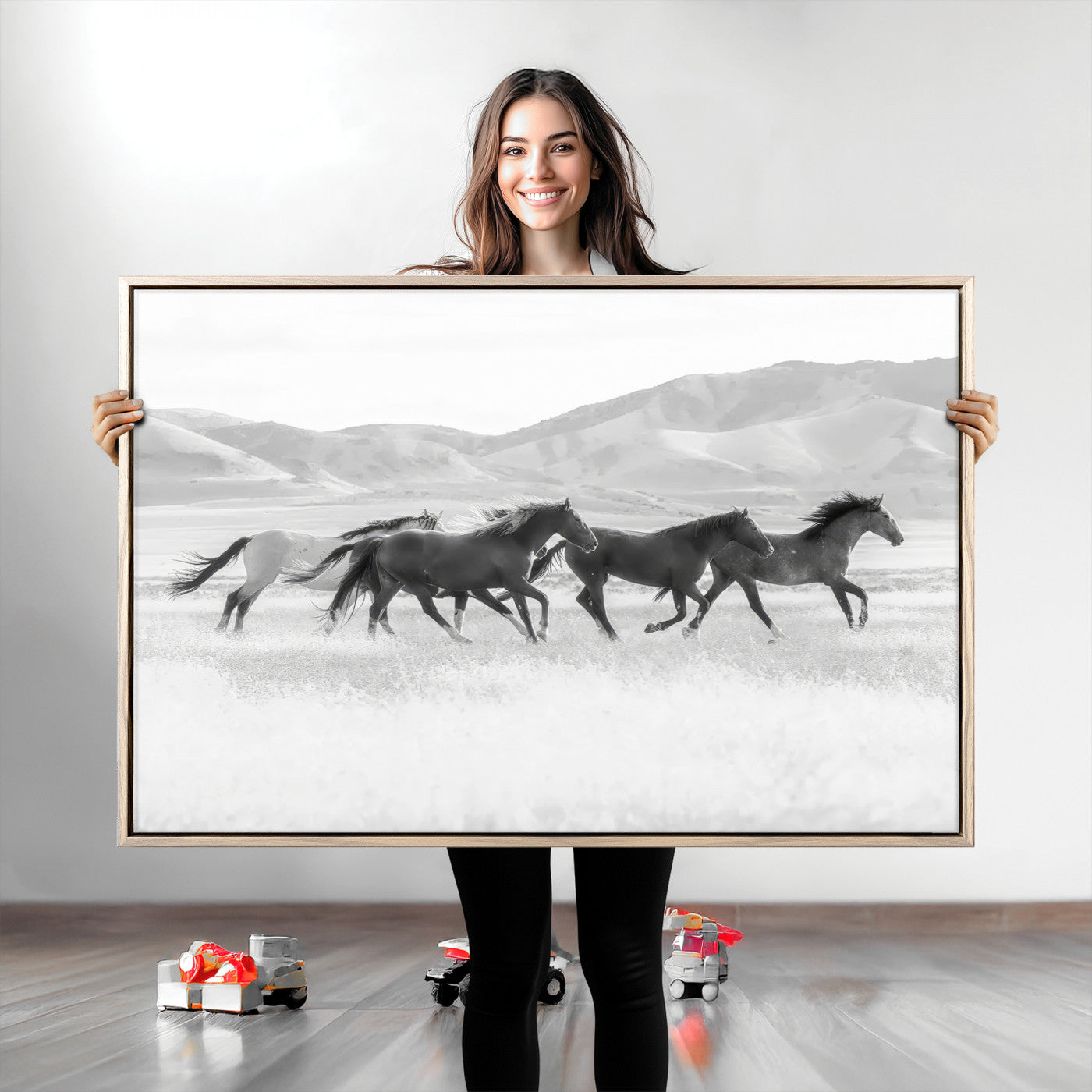 A black and white image of wild horses running freely across an open grassland, capturing the power and beauty of untamed nature in a rustic western setting.
