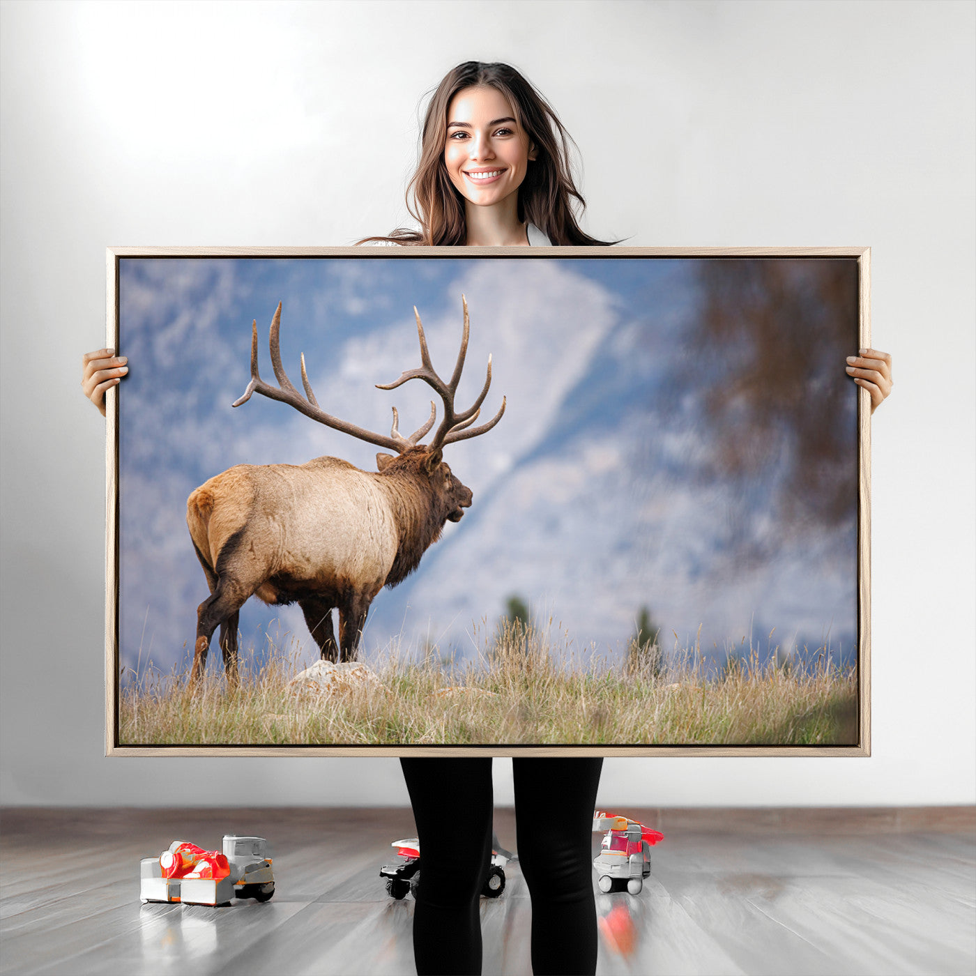 Elk with antlers standing on grass with mountain background, ideal for rustic, cabin, or lodge-inspired wall decor.