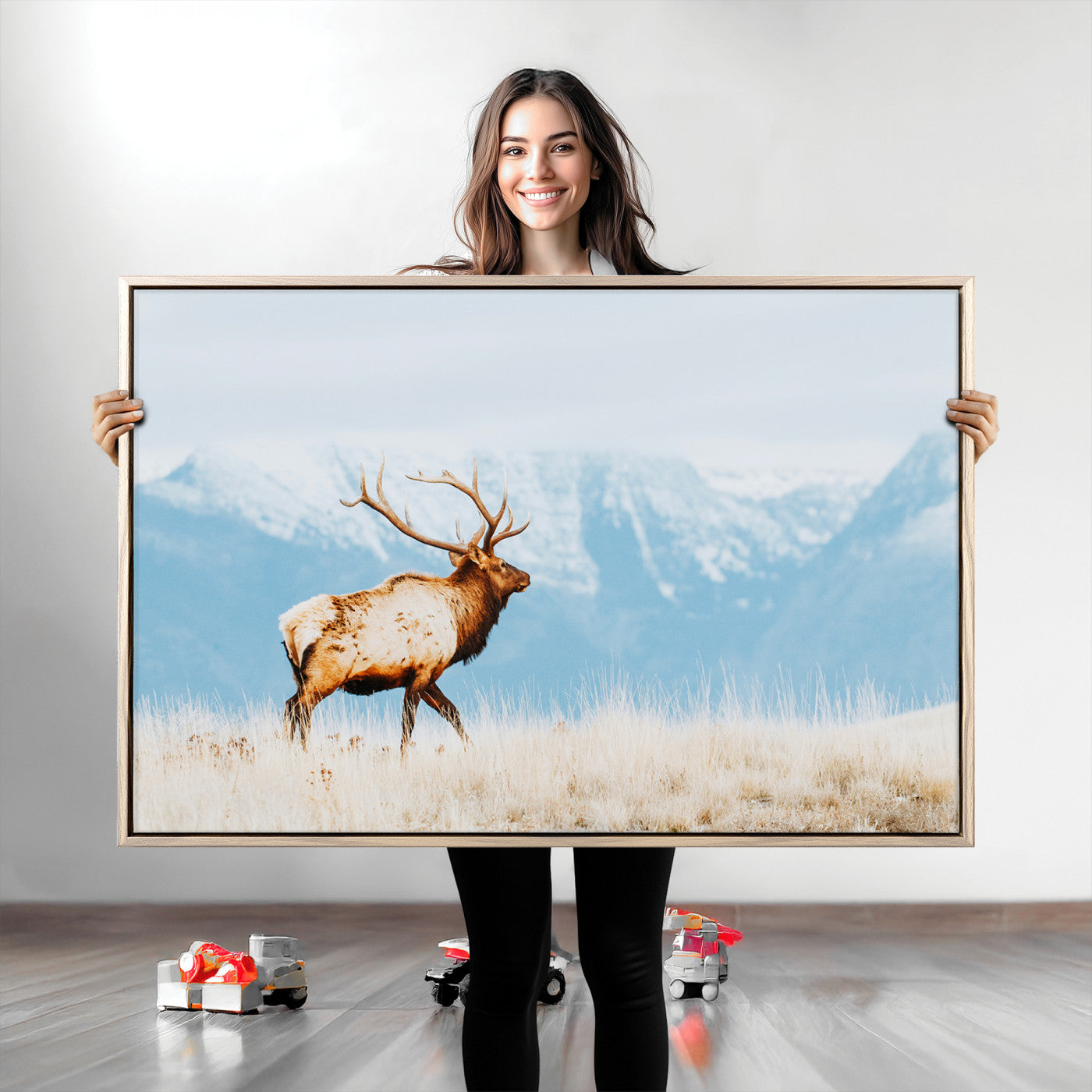 Majestic elk standing on dry grassland with snowy mountains in the background, ideal for rustic or lodge-inspired wall decor.