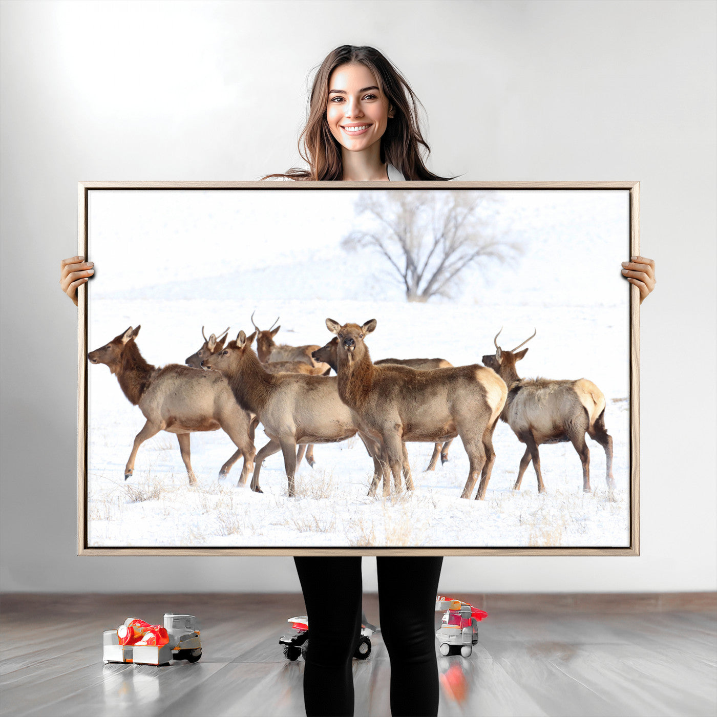 A group of elk standing on snowy terrain with a tree in the background, perfect for rustic or lodge-style winter wall decor.