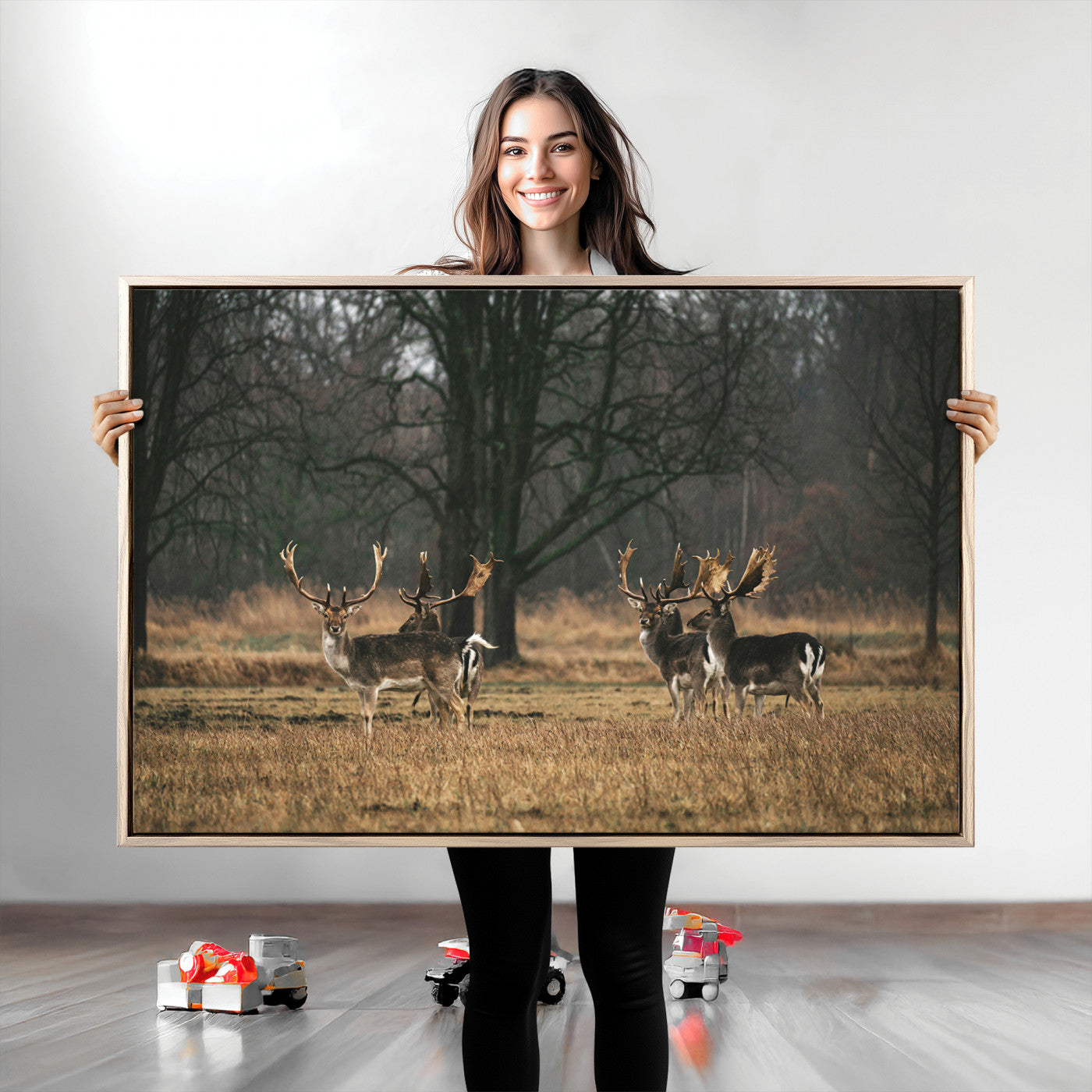 A group of majestic deer standing in a golden field with bare trees in the background, creating a peaceful woodland scene.