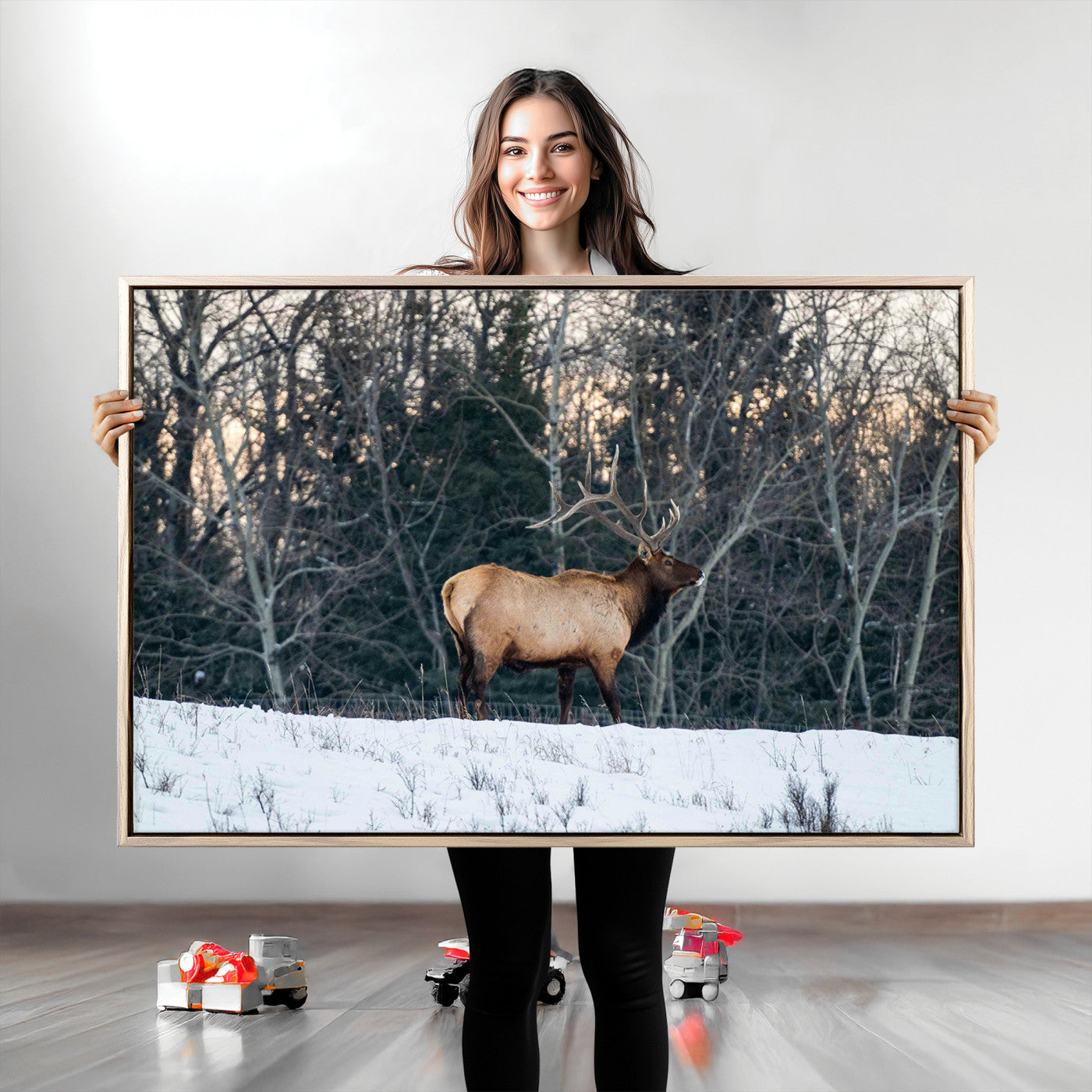 A majestic elk with large antlers standing in a snowy field against a winter forest backdrop, perfect for rustic and wildlife-themed home decor.