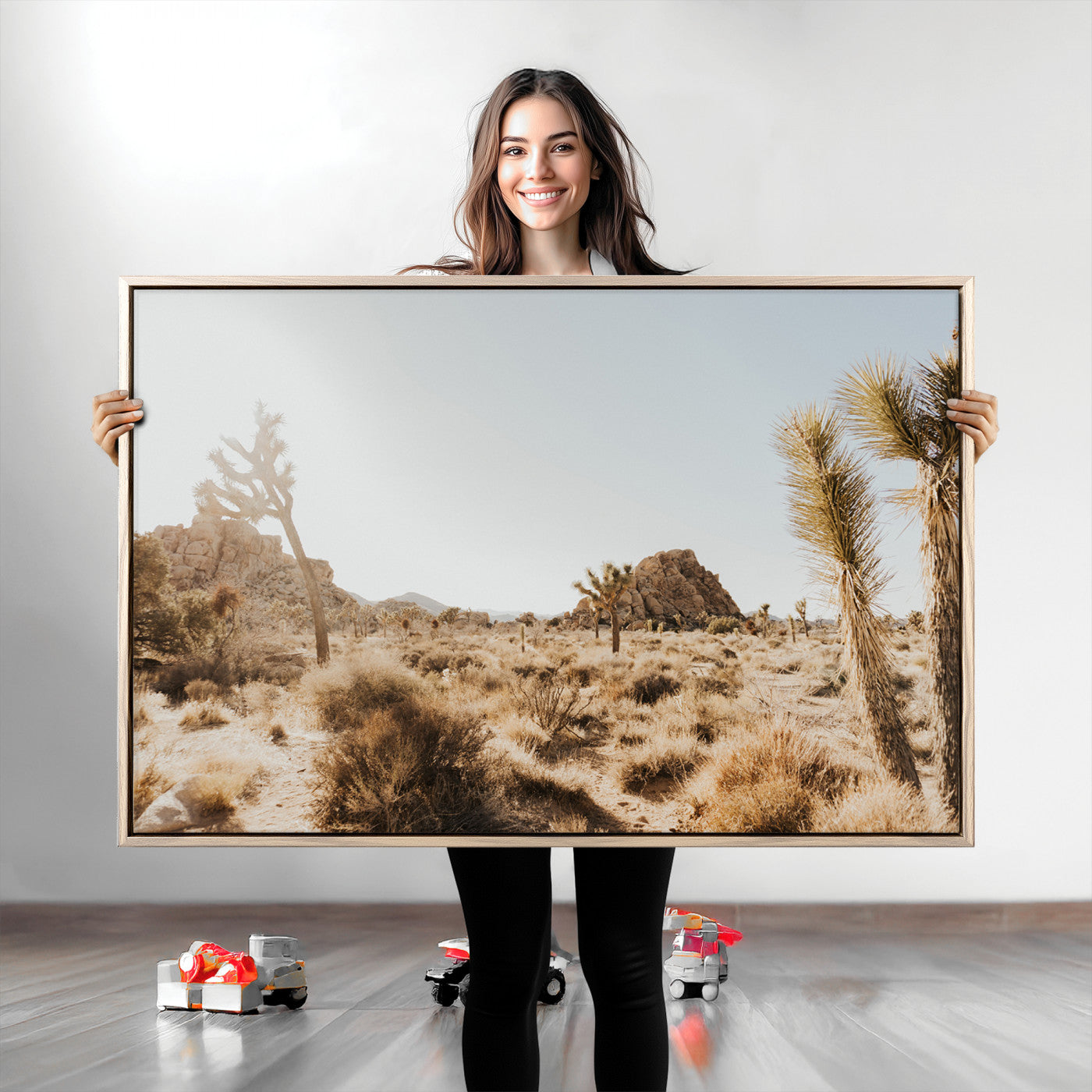 Sunlit desert landscape featuring Joshua trees, rocky formations, and dry bushes under a clear sky.