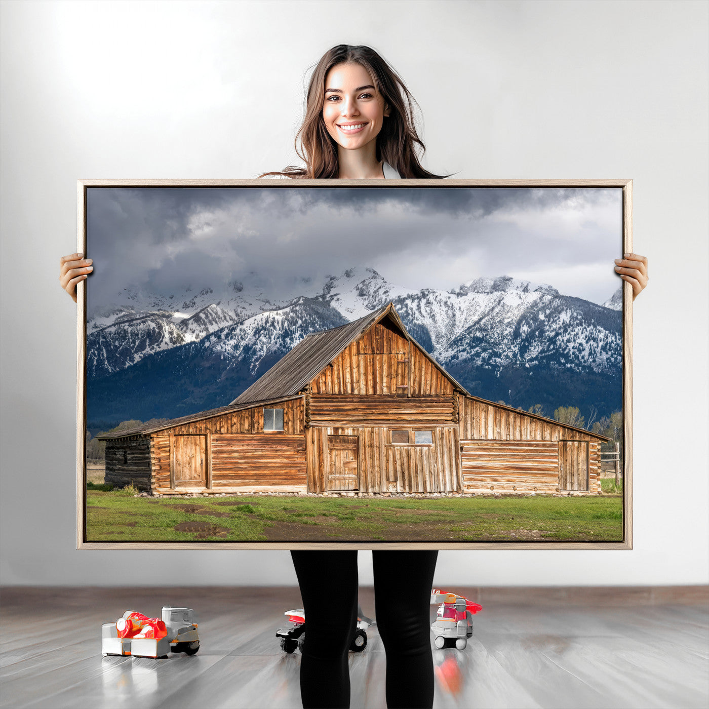 A stunning wall art canvas print featuring a rustic wooden barn set against a backdrop of snow-capped mountains under a dramatic cloudy sky, perfect for adding a touch of rural charm to any space.