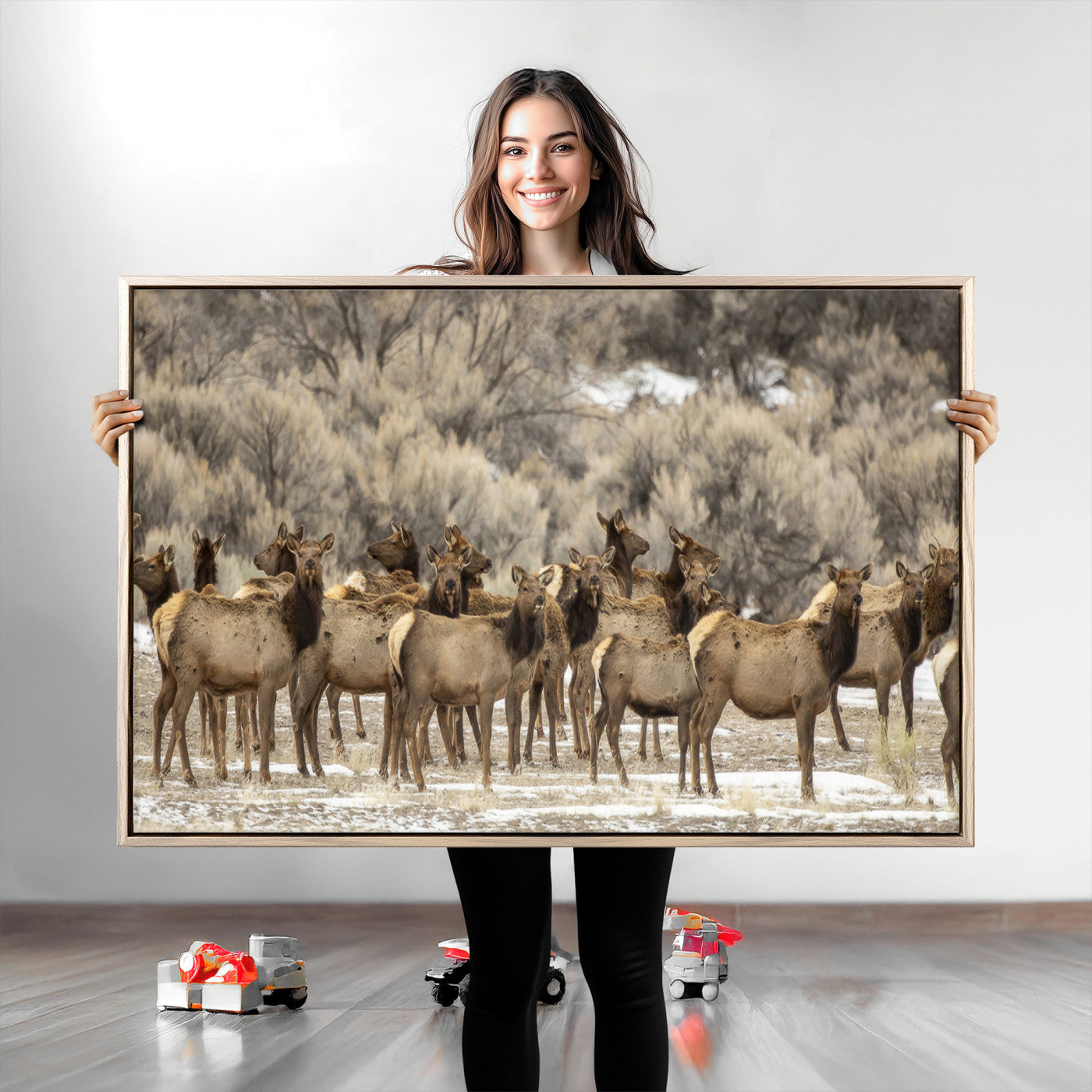 A stunning wall art canvas print featuring a large herd of elk standing together in a natural winter landscape with muted earthy tones and soft background foliage, perfect for rustic or nature-inspired home decor.