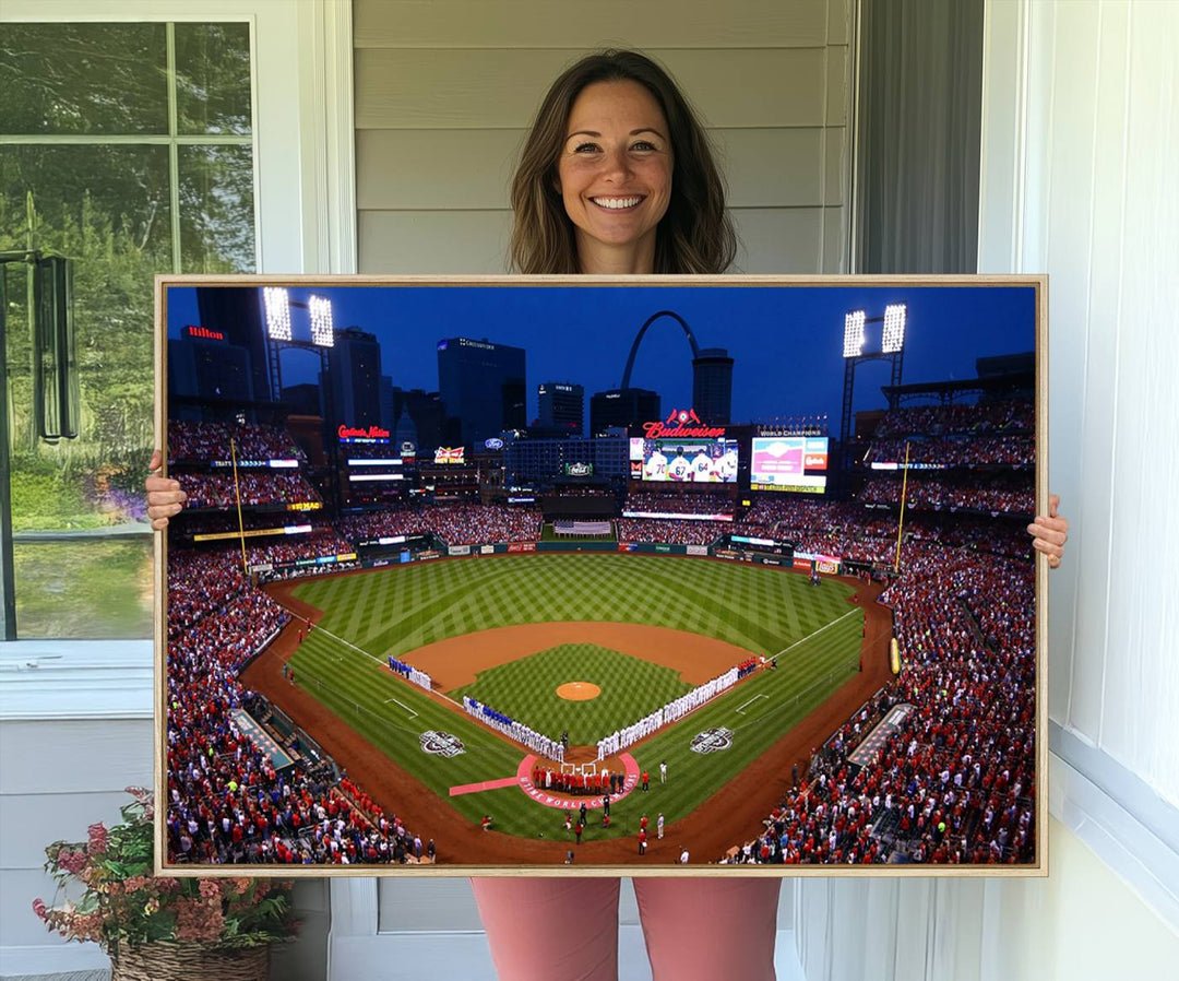 A Cardinals wall art canvas print depicts Busch Stadium with players lined up on the field and a full audience under the lights, capturing the vibrant atmosphere.