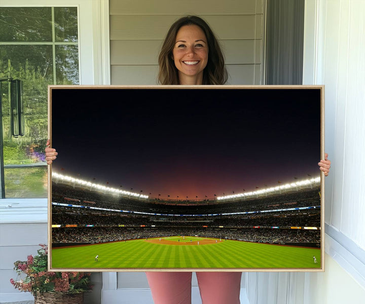 A night game at Yankee Stadium depicted on canvas beneath a sunset sky.