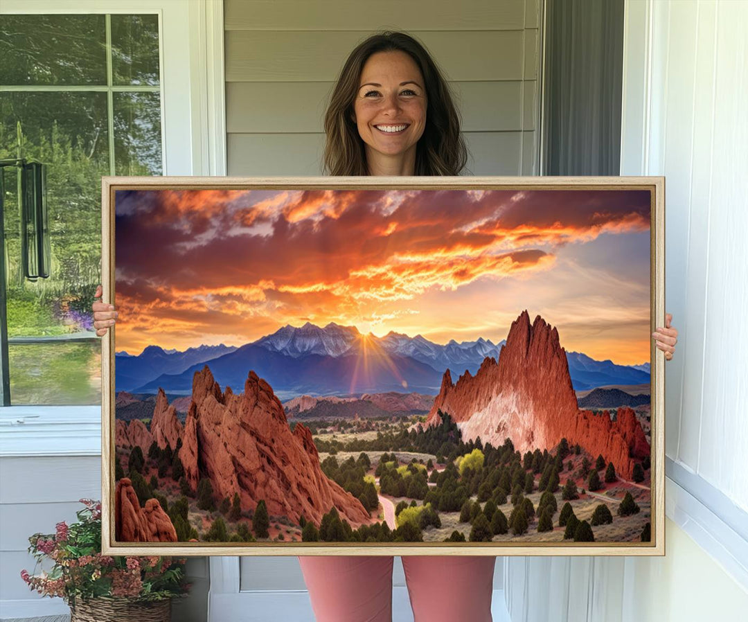 A vibrant sunset over the Rocky Mountains with red rocks.