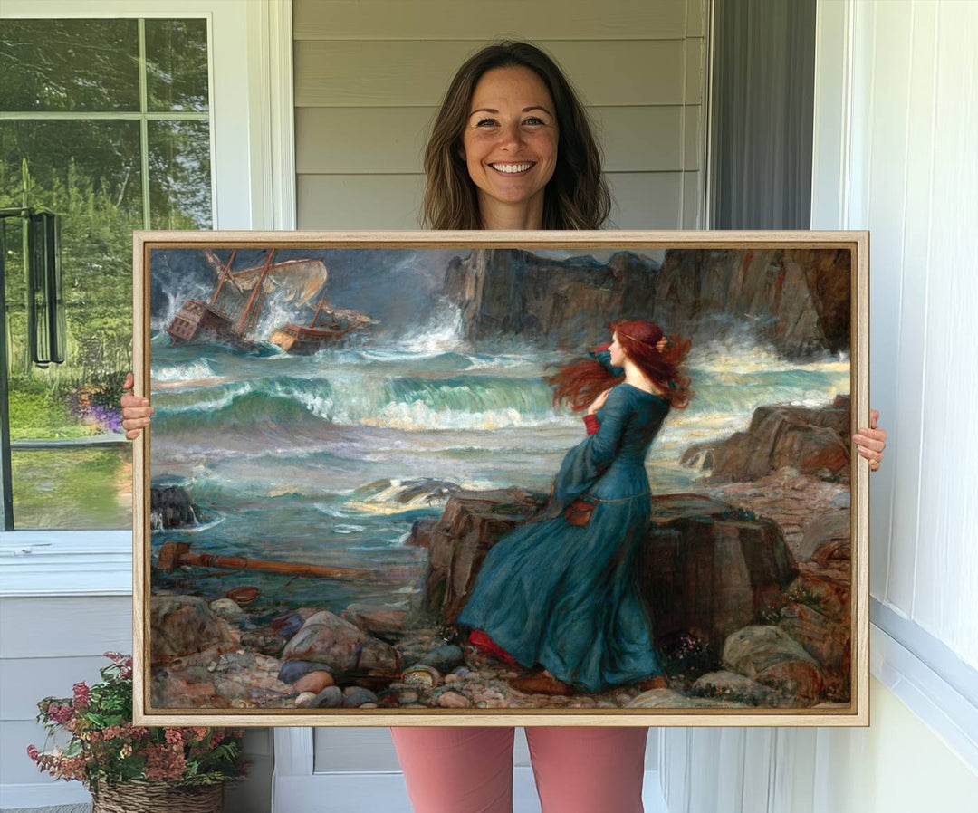 The Miranda by the Shore Wall Art Canvas Print depicts a woman in a blue dress standing by the sea, watching a shipwreck.