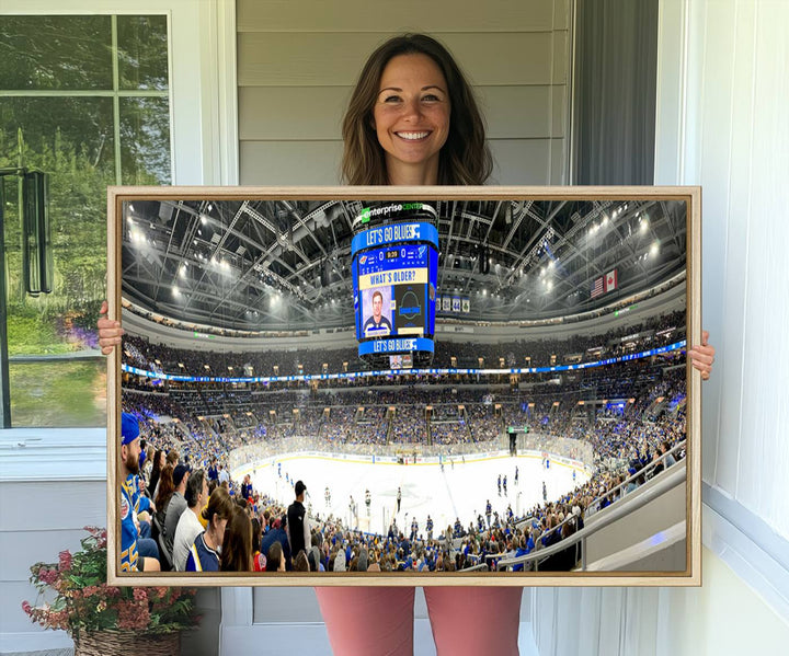 Wall art prints depicting the bustling scenes of the St. Louis Blues being cheered on by a full house at the Enterprise Center, beneath a large scoreboard.