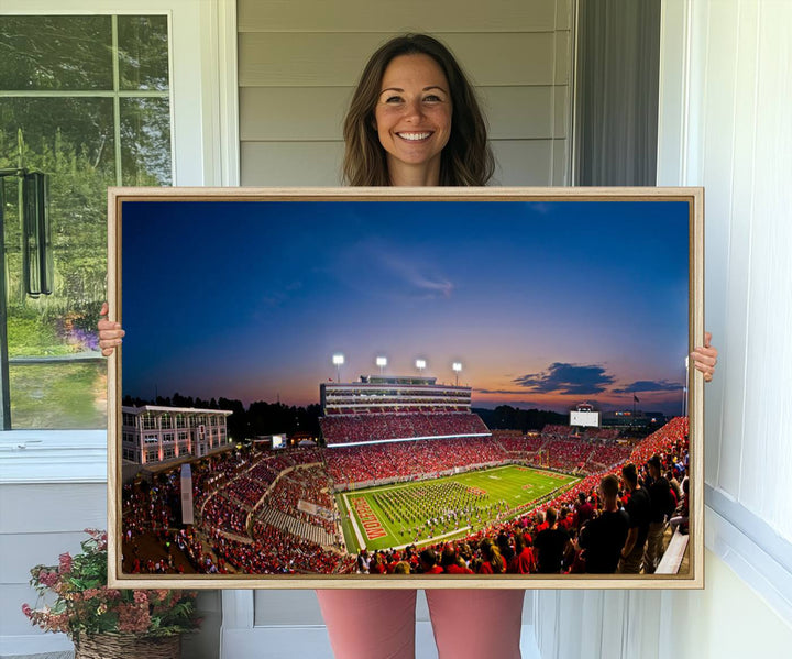 A vibrant and dynamic painting captures the essence of an electrifying night game at Carter-Finley Stadium, highlighting the illuminated atmosphere as the NC State Wolfpack competes under bright stadium lights.