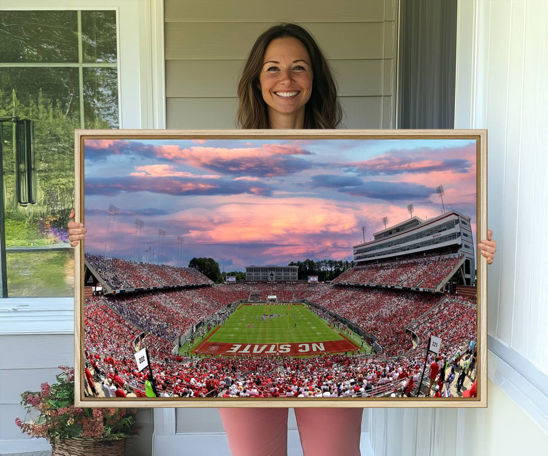 The wall art captures an NC State Wolfpack game under a vibrant sunset on triple canvas.