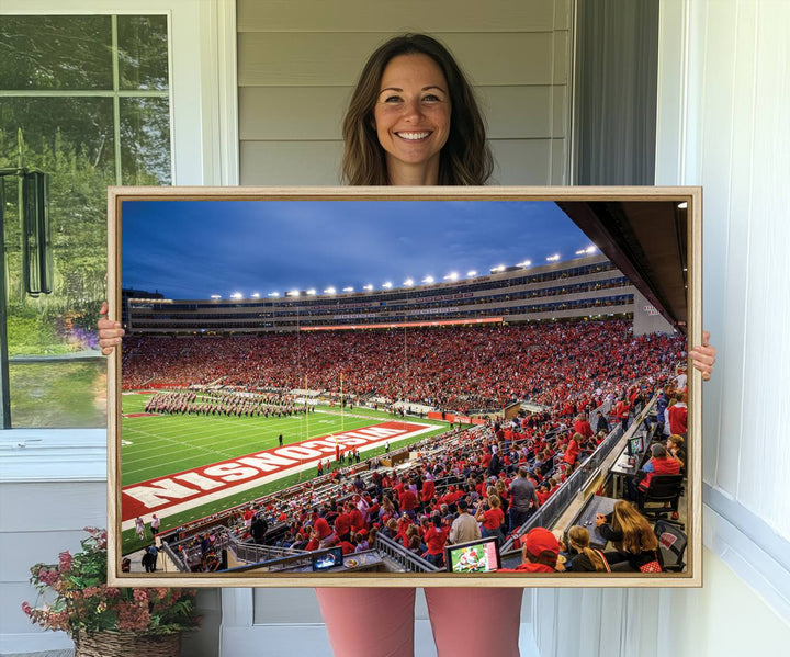 A vibrant wall art captures the essence of Madison Camp Randall Stadium, depicting a sea of fans in red and white during a Wisconsin Badgers football game under bright lights.