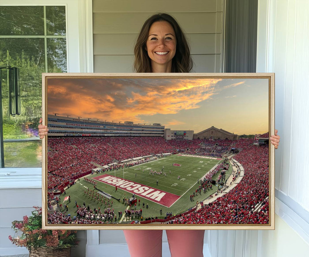 The wall features a Wisconsin Badgers wall art canvas print, capturing the vibrant atmosphere of a full Camp Randall Stadium at sunset.