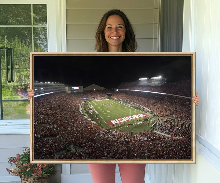 A painting of a stadium packed for a Wisconsin Badgers game, with WISCONSIN clearly visible in the end zone at Camp Randall Stadium.