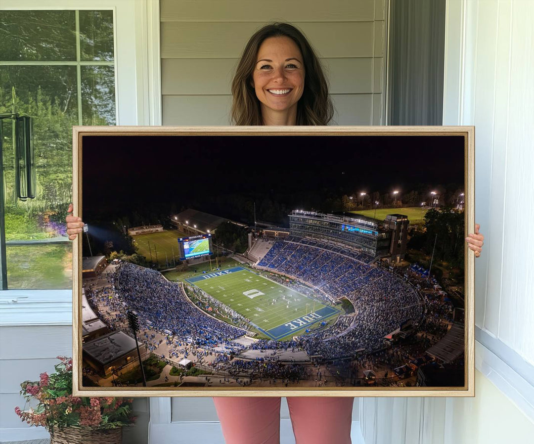 Night aerial view of packed Duke Blue Devils Wallace Wade Stadium, surrounded by trees and illuminated by lights; perfect for high-resolution prints.