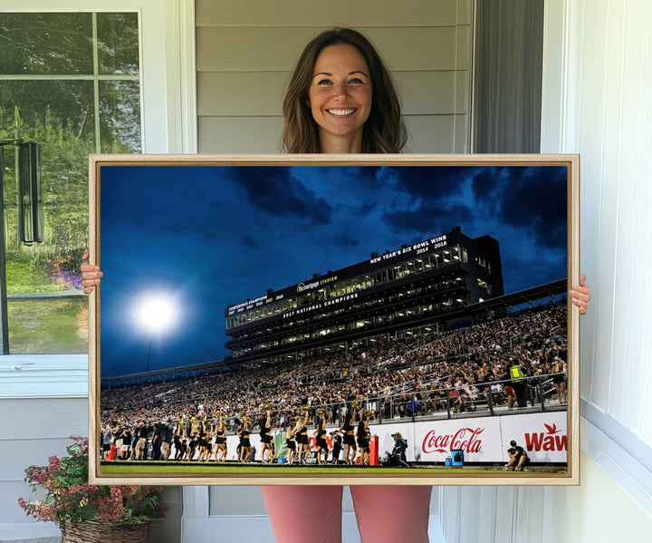 A gallery-quality canvas print depicting a stadium packed with fans under a night sky, highlighting the UCF Knights Football Team.