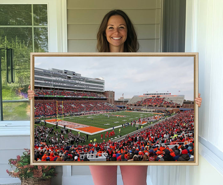 A University of Illinois Fighting Illini wall art canvas hangs on the wall, depicting a packed stadium.