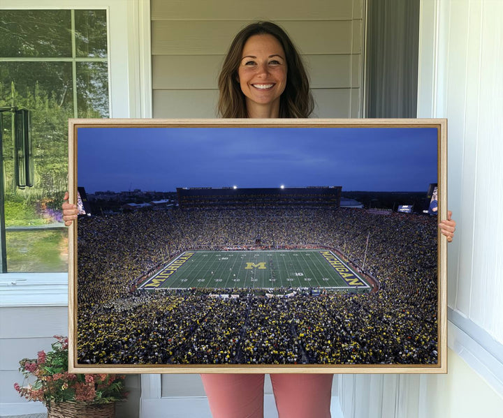 Wall art featuring an aerial shot of Michigan Stadium at dusk, showcasing the University of Michigan Wolverines M logo.