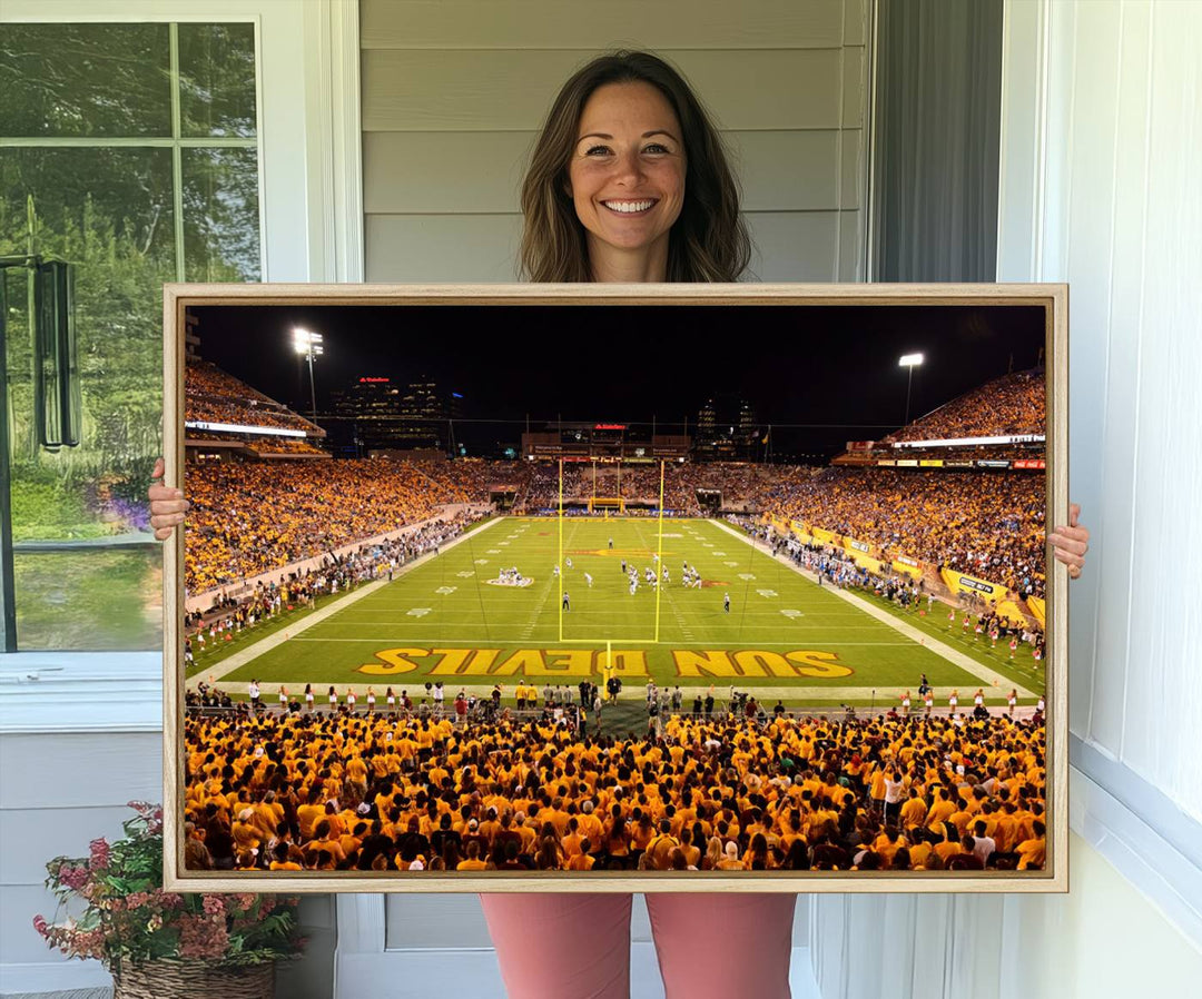 The Phoenix Stadium Canvas Wall Art features a vibrant depiction of a packed stadium filled with ASU Sun Devils fans wearing yellow shirts.