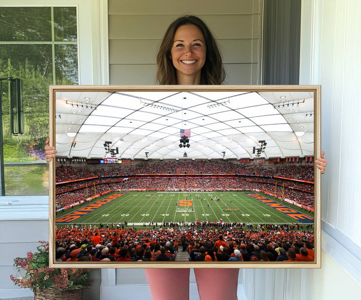 Fans fill the Syracuse JMA Wireless Dome, highlighted in orange and blue under a vaulted roof on this premium canvas print of the scene.