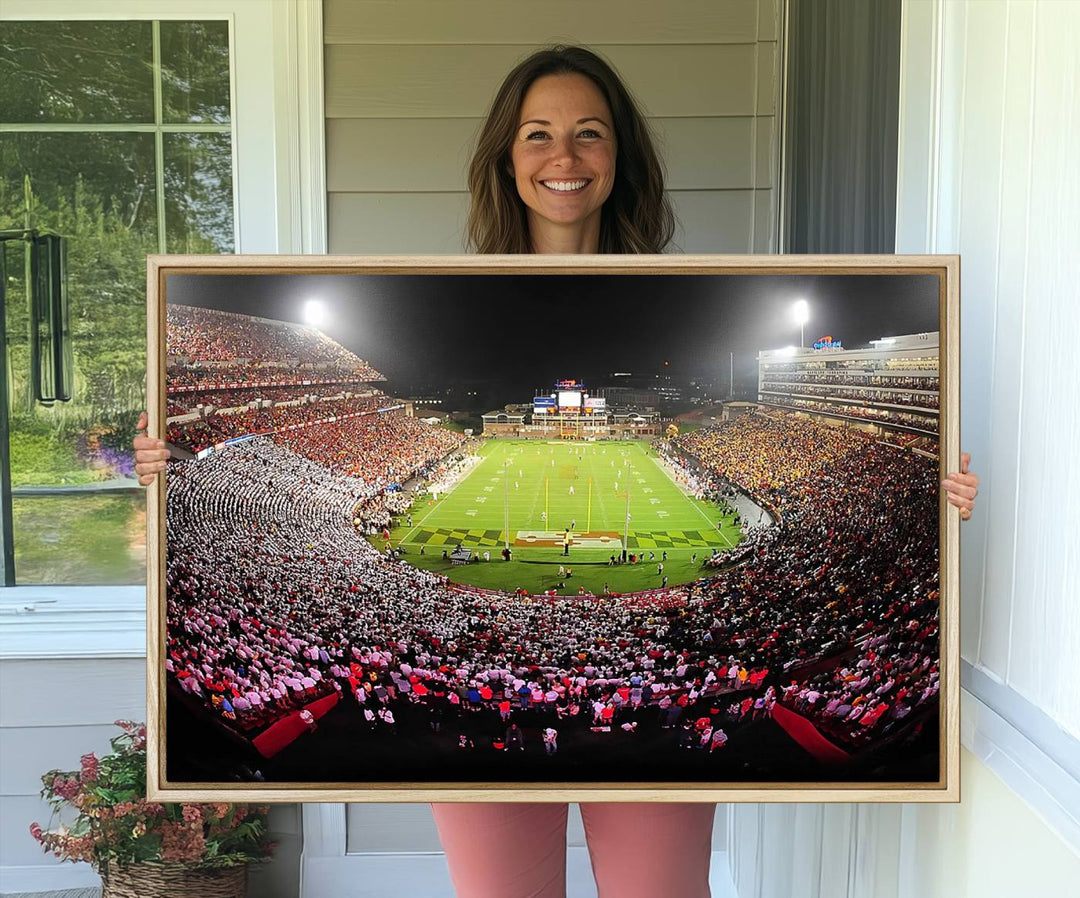 The Maryland Terrapins Football Wall Art Canvas showcases a packed SECU Stadium at night with a bright field and cheering fans.