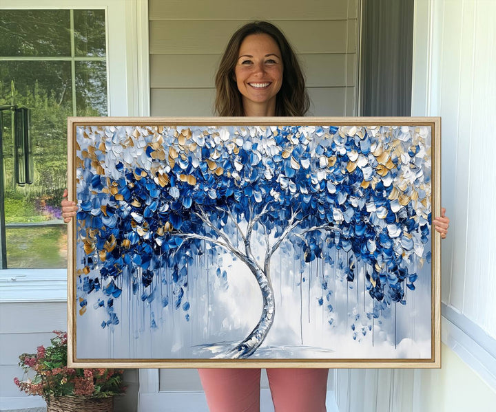 The Blue and Gold Abstract Tree Wall Art showcases a swirl trunk and features blue, silver, and gold leaves on a framed canvas print.