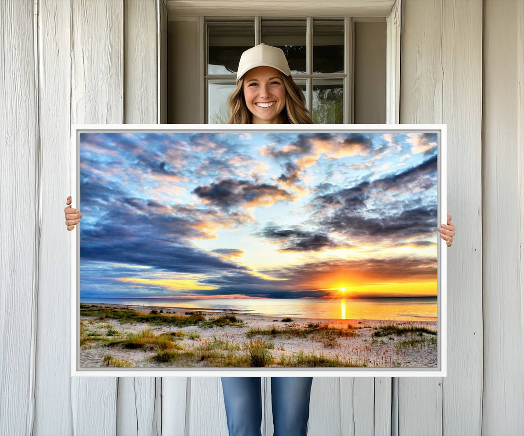 The Sunset On The Ocean canvas wall art features a beautiful beach sunset with grass and clouds.