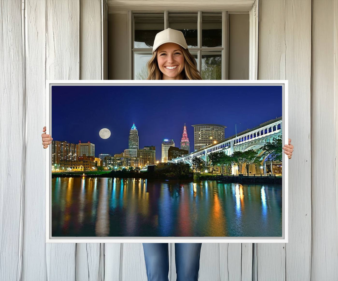 Cleveland City Lights Night Skyline Wall Art canvas showcases a moonlit cityscape reflected on water.