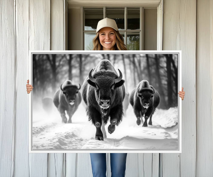 The Buffalo Wall Art Canvas Print of bison running through snow adorns the wall.