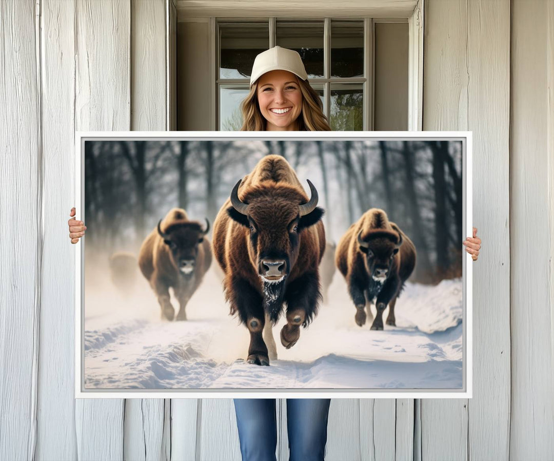 Wall art titled Cow Bighorn shows three bison running through snow in a forest.