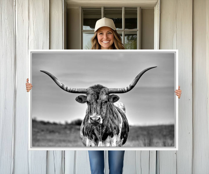 The Texas Longhorn Cow wall art, divided into three panels, is of gallery quality and displayed on a dark wall.