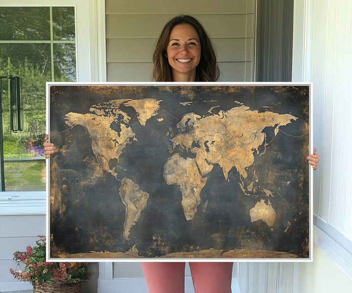 The Grunge World Map Canvas Wall Art features golden tones and is displayed against a white-paneled wall.