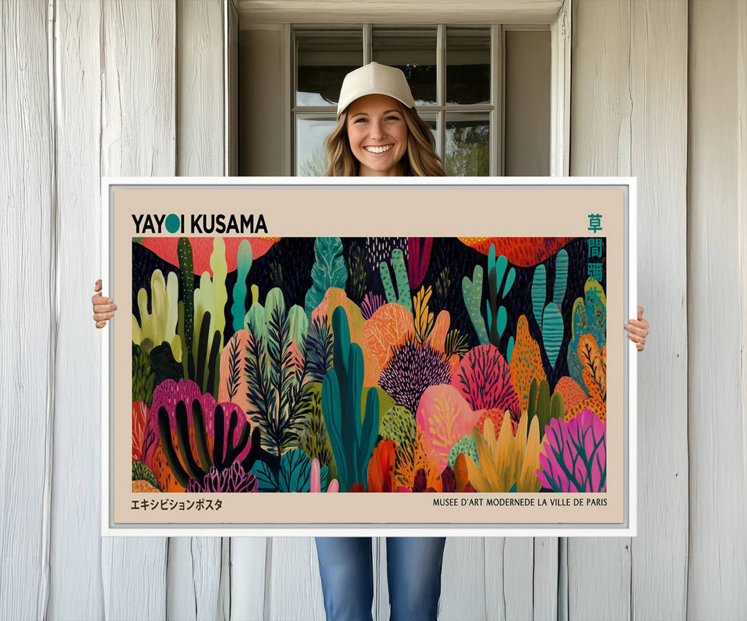 The vibrant canvas print of wall art features abstract plants, with the elegant text "Yayoi Kusama Wall Art Canvas Print" displayed on the colorful frame.