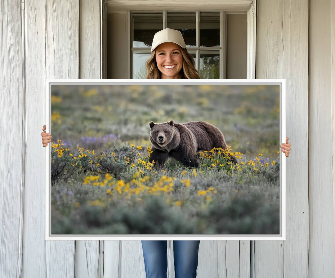 The "Grizzly 399 in Wild Flowers Wall Art Canvas Print" features a grizzly bear strolling through a field of yellow and purple flowers, beautifully showcased as a triptych. This handcrafted piece, proudly made in the USA, adds charm and sophistication to your space.