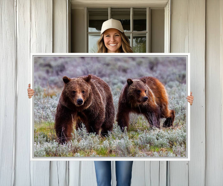 The "Queen of the Tetons" is a stunning canvas art print featuring Grizzly 399 and two bears strolling through a grassy field. Its gallery-quality finish beautifully captures the essence of nature, making it perfect for rustic home decor.