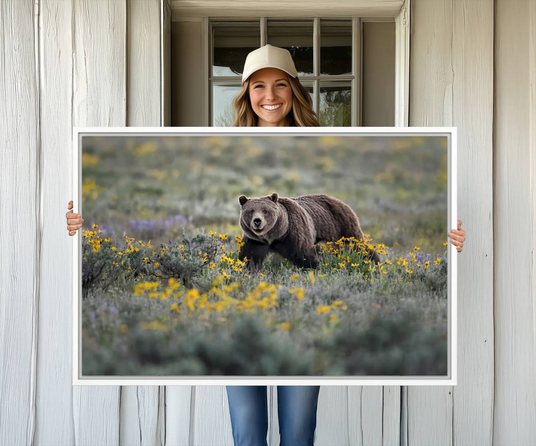 The "Queen of the Tetons" is a stunning canvas wall art print featuring Grizzly 399 walking through a field of yellow and purple flowers, showcasing the gallery-quality finish.