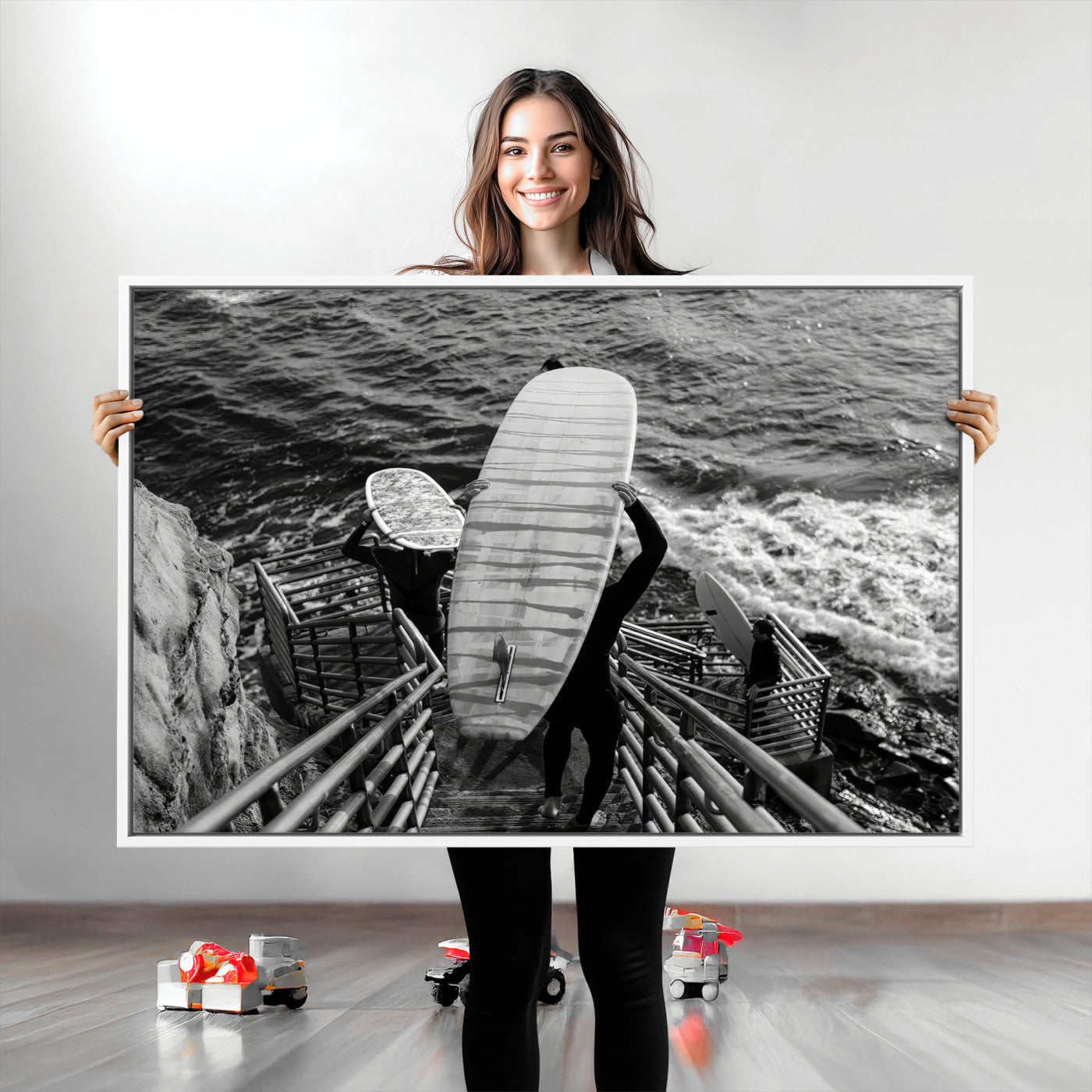 Black and white photo of surfers carrying boards down a rugged cliffside stairway, capturing a bold and adventurous coastal scene.